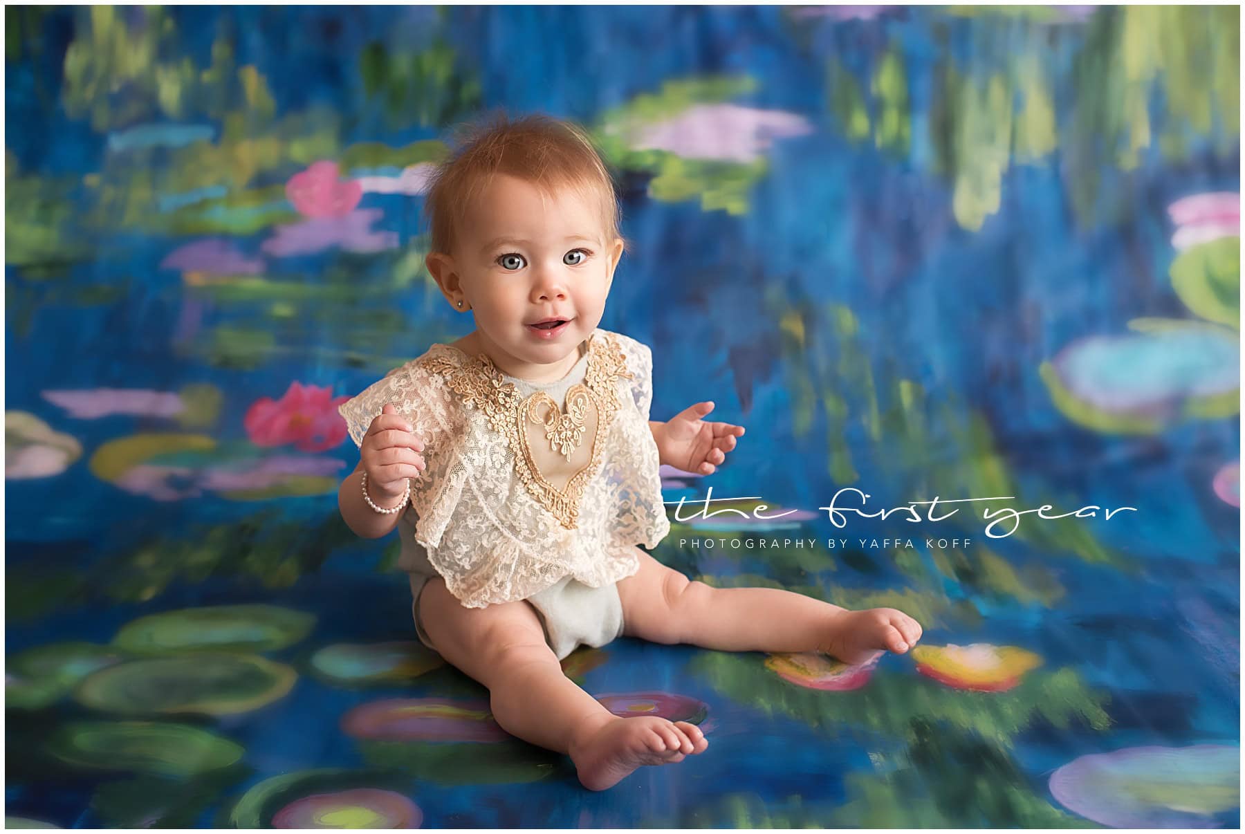 Baby girl sitting on colorful water lily backdrop in studio.