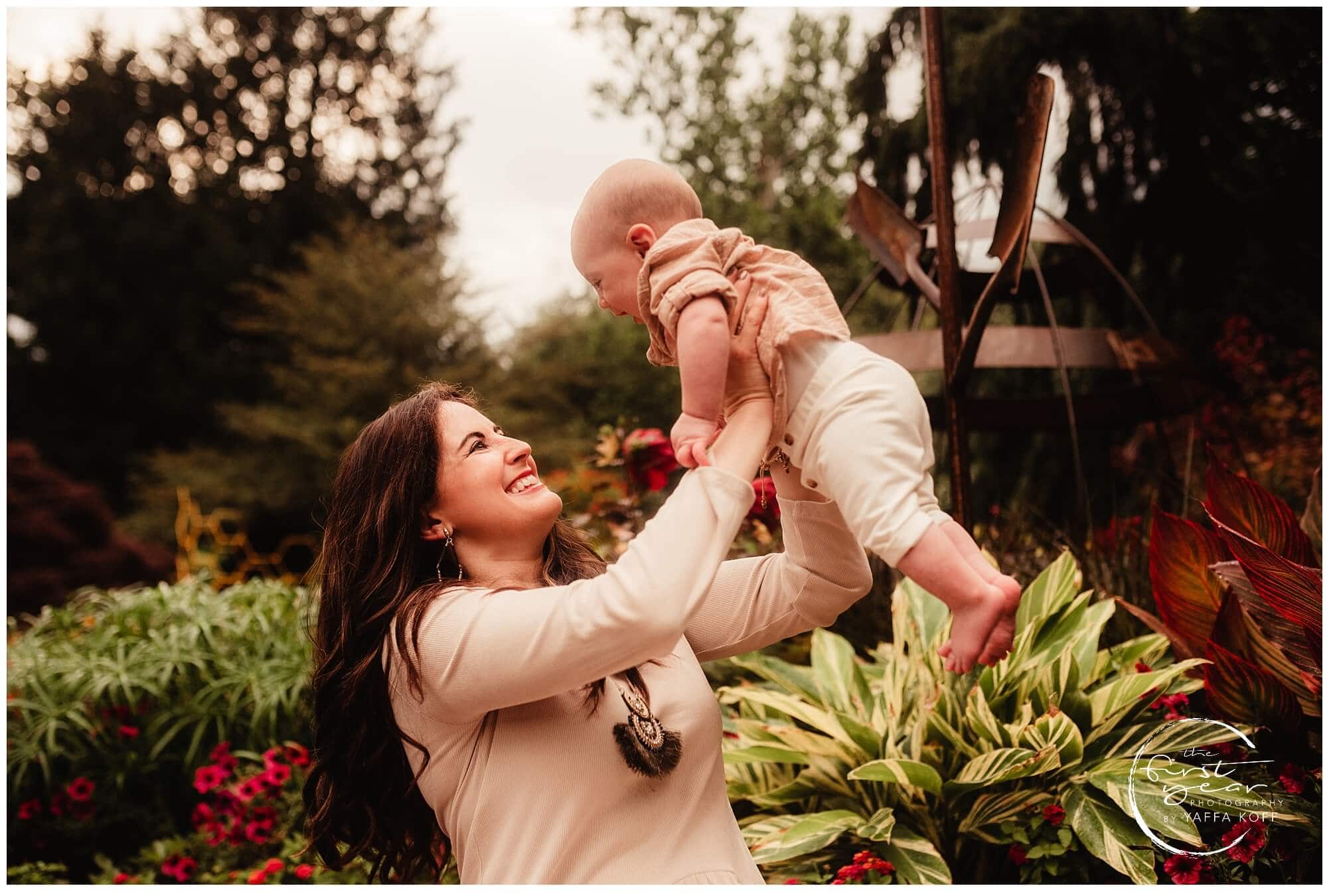 Smiling woman lifting a baby outdoors during a family photoshoot in Silver Spring, Maryland.