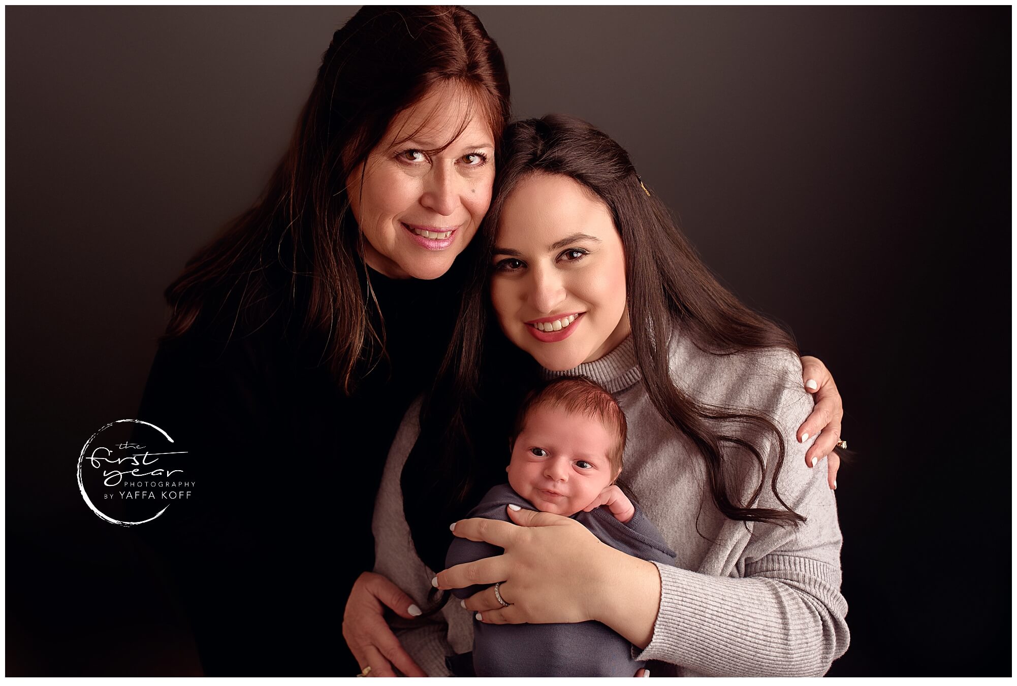 Close-up of mother, daughter, and newborn baby Nathan smiling together in a professional studio.