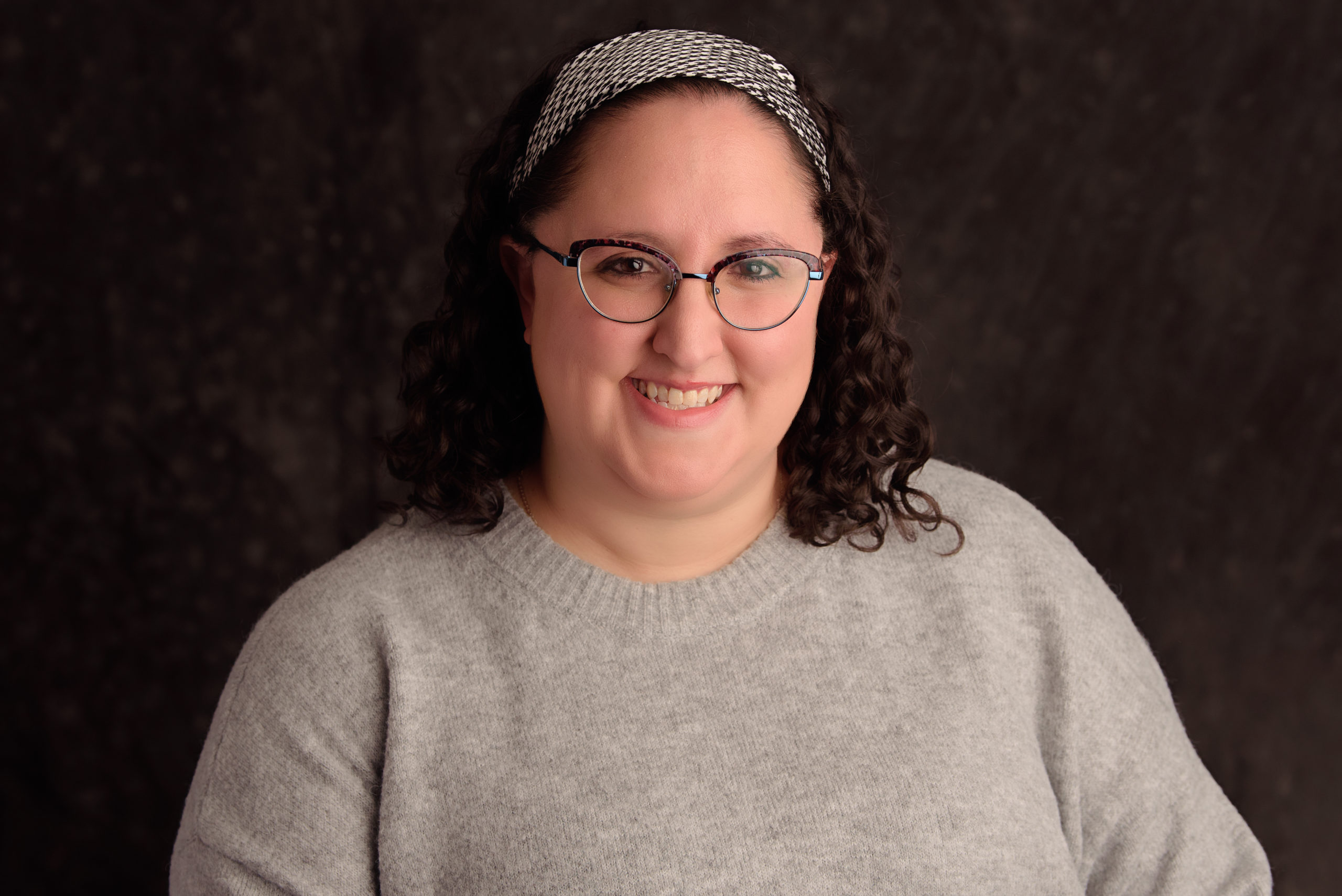 Midwife smiling in a professional portrait, representing compassionate maternal care in Silver Sprin.