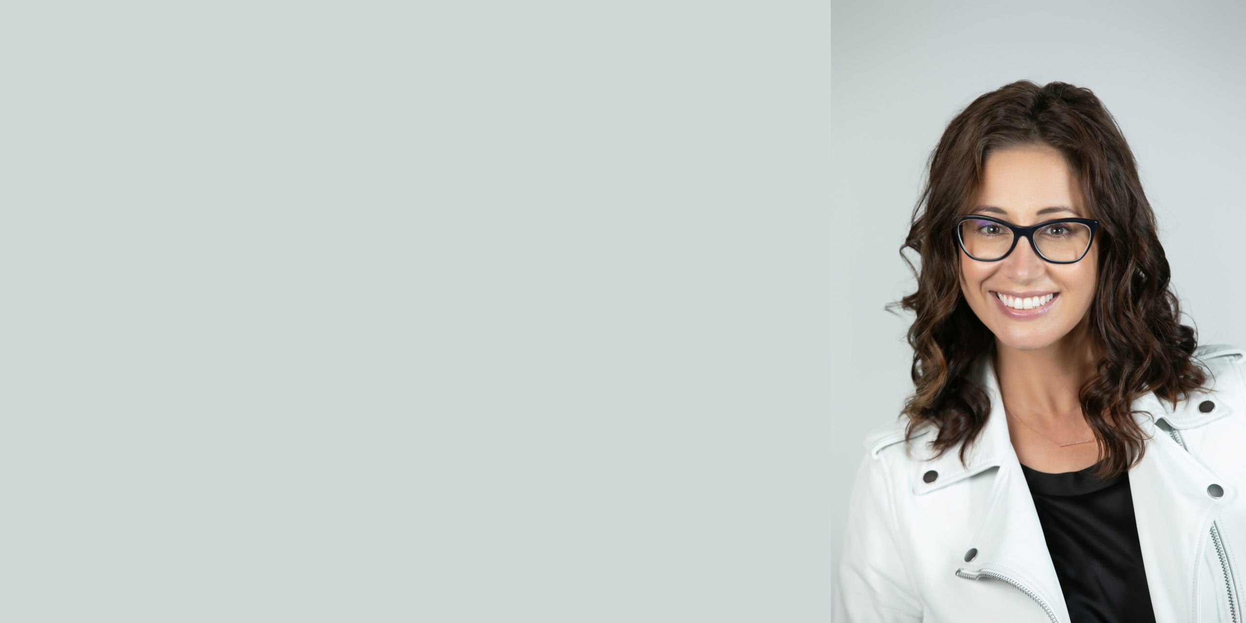 Portrait of a smiling interior designer with glasses in a bright studio.