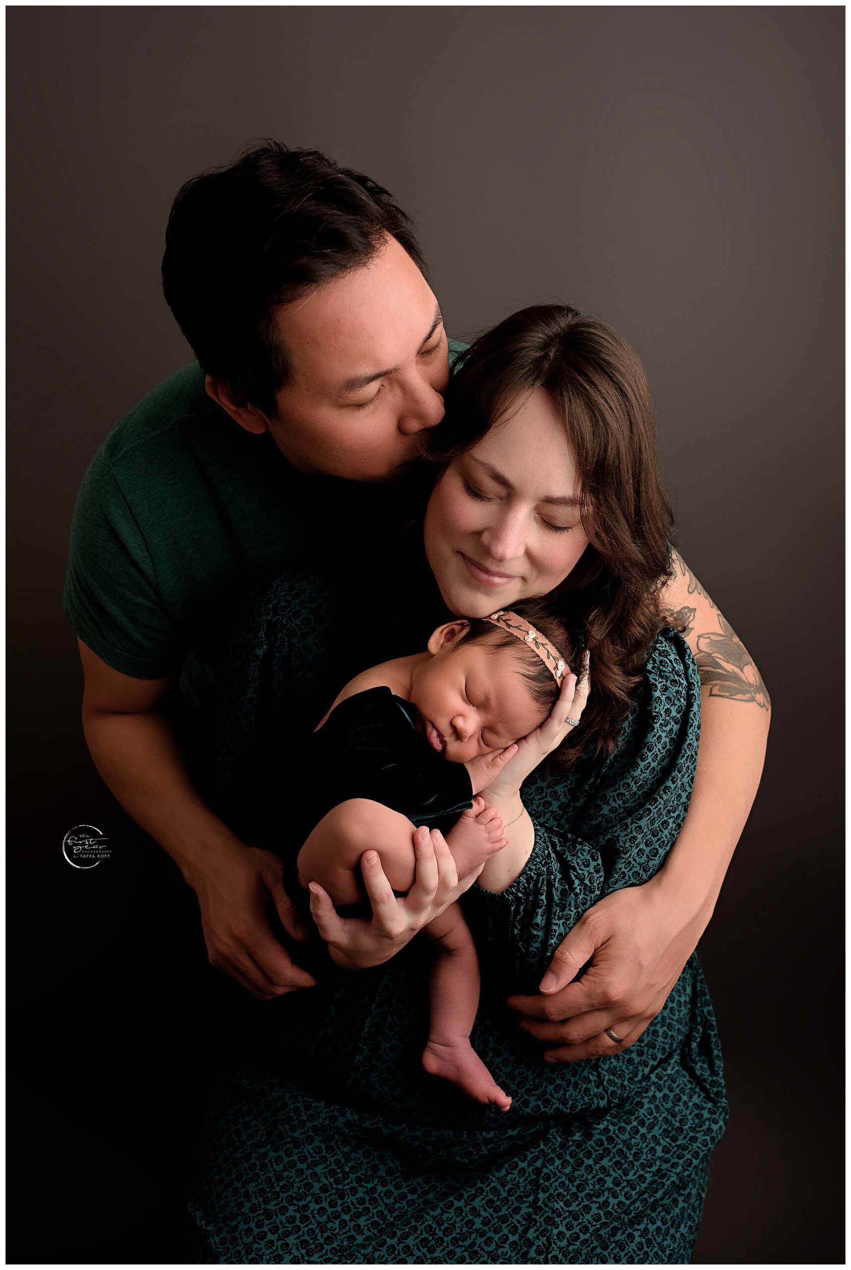 Beautiful newborn with parents in a cozy studio setting.