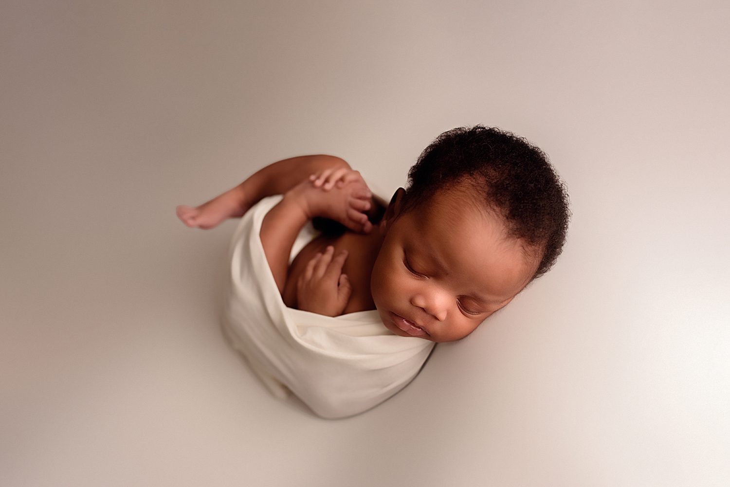 small baby wrapped in white cloth by Silver Spring Family Photographer