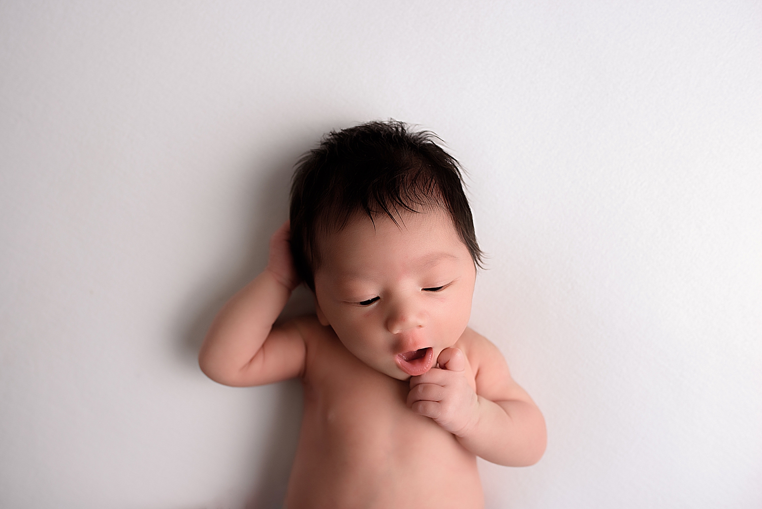 dark haired infant on white backdrop by Silver Spring Family Photographer