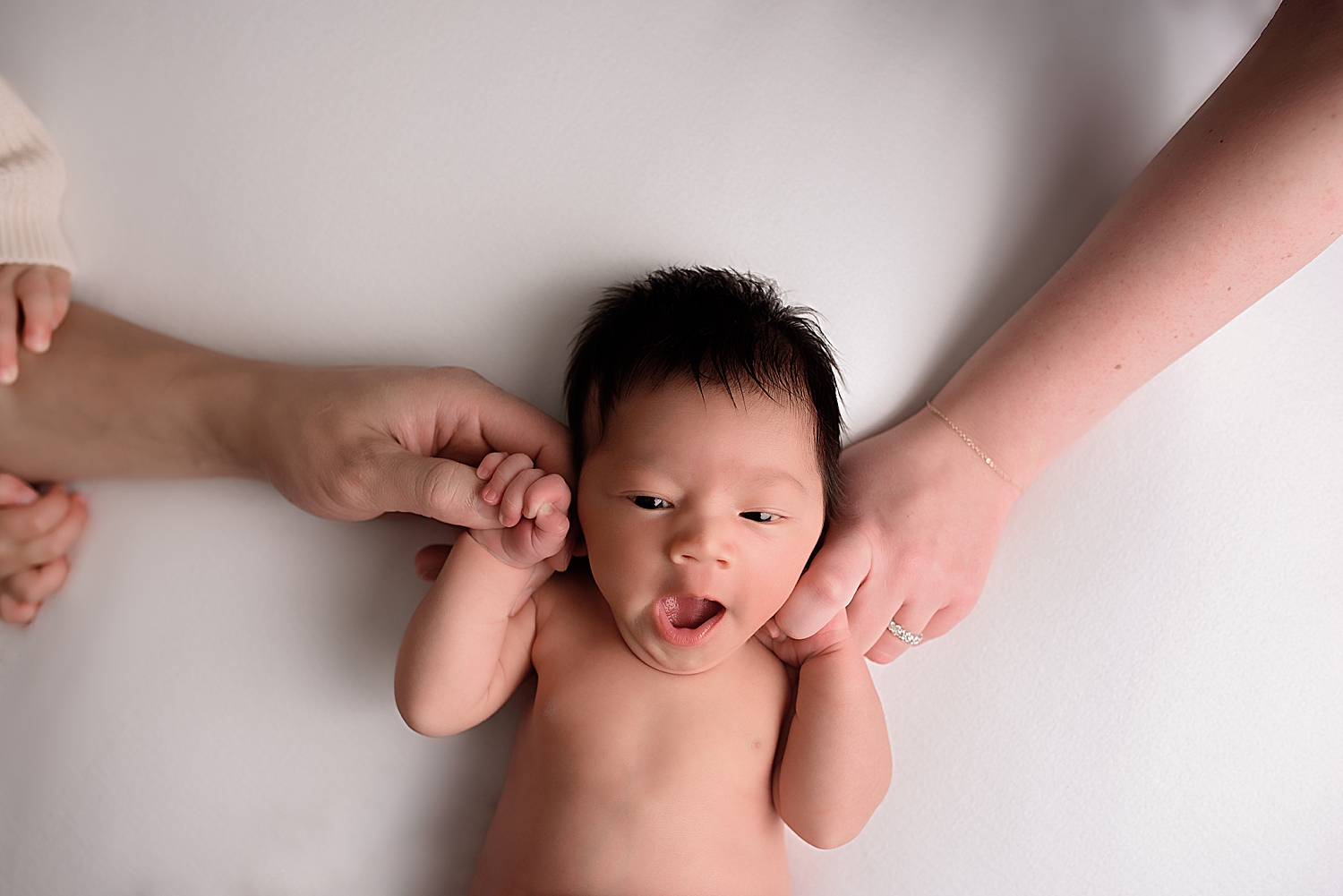 little one holds onto family's hands by Yaffa Koff Photography