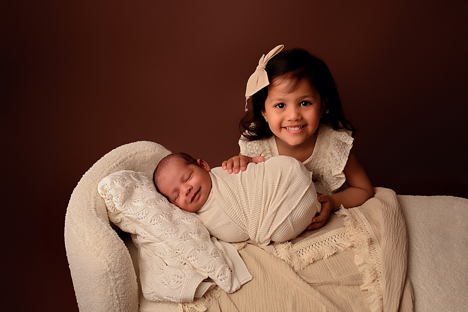 sister leans over new baby by Yaffa Koff Photography