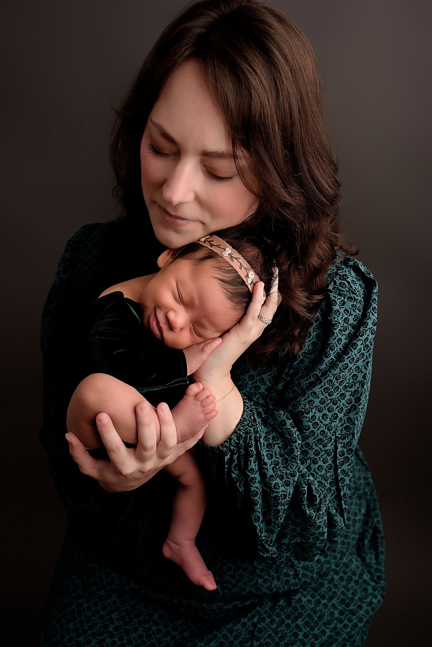 brunette mother holds her infant close by Silver Spring Newborn Photographer 