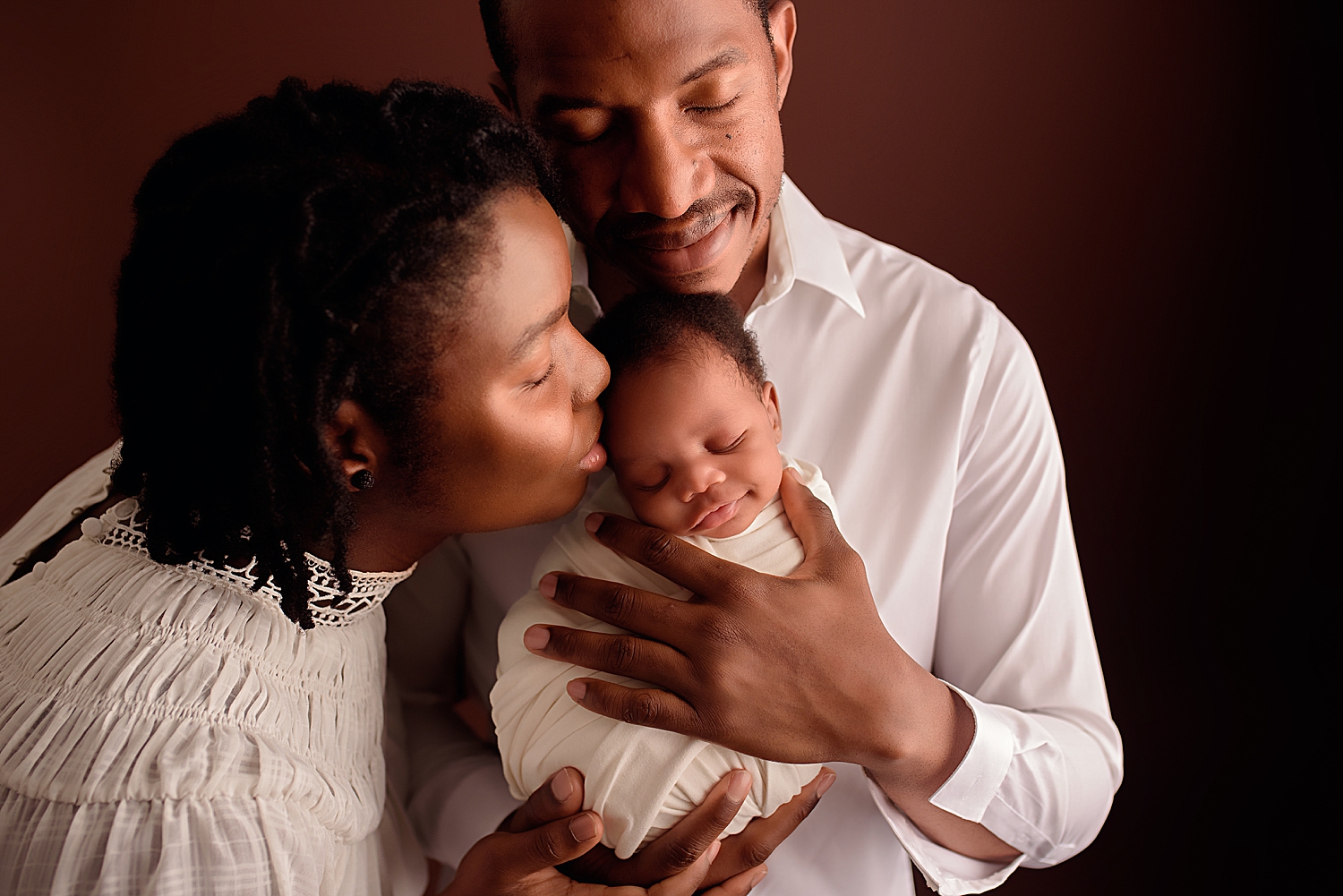 mom leans in to kiss her babe while learning how to get baby to smile