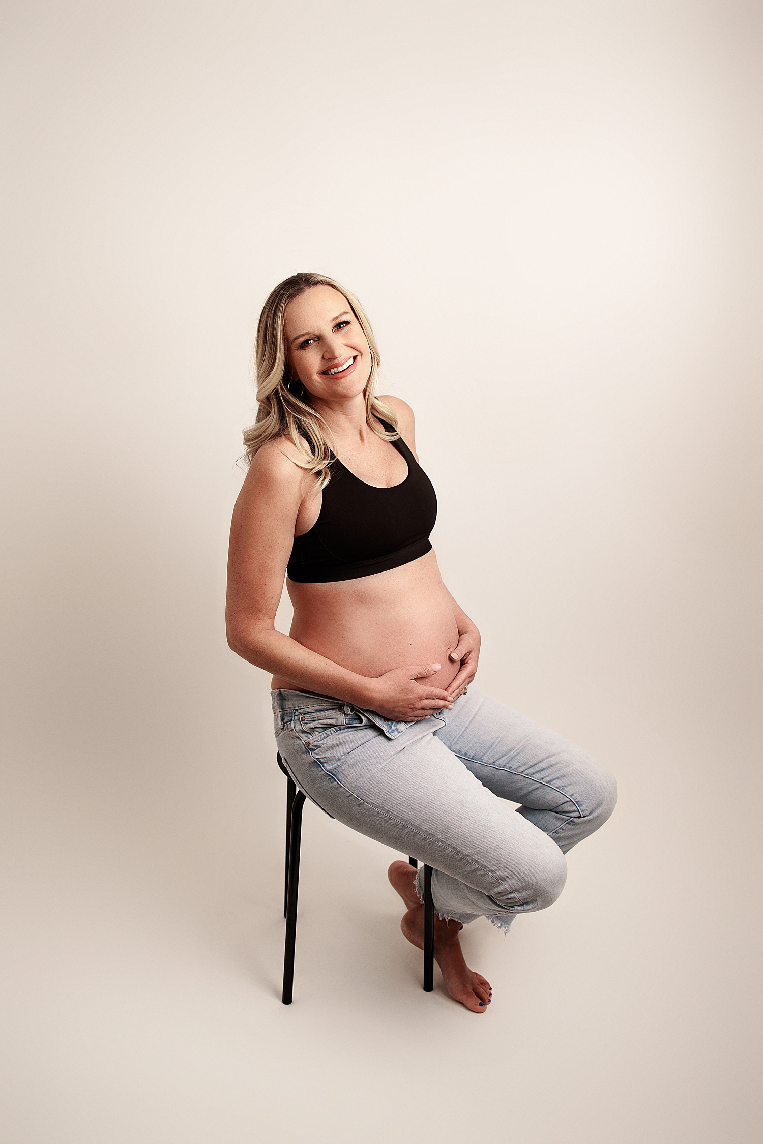 blonde expecting mama sits on stool by Yaffa Koff Photography