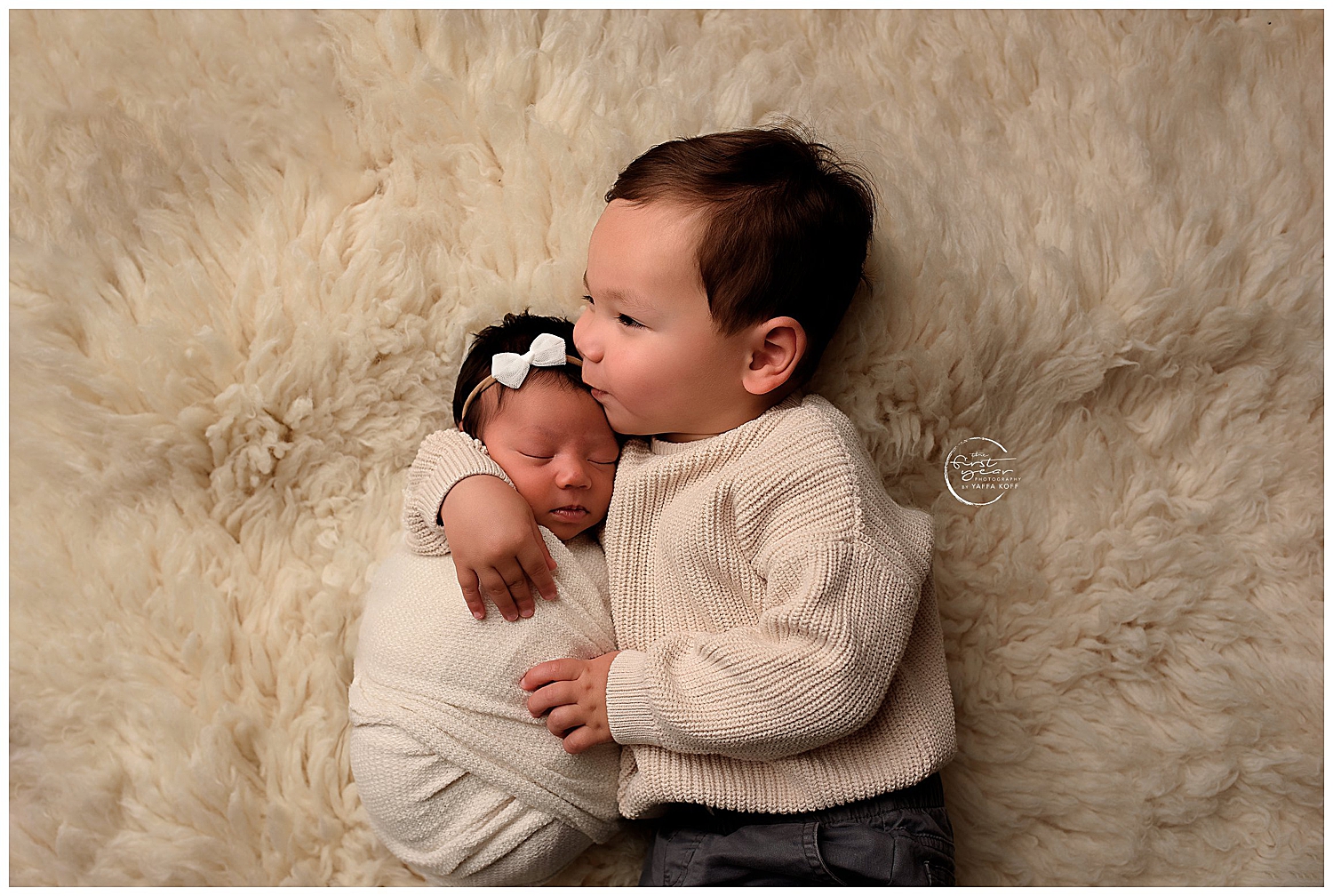 toddler in cable sweater hugs baby by Yaffa Koff Photography