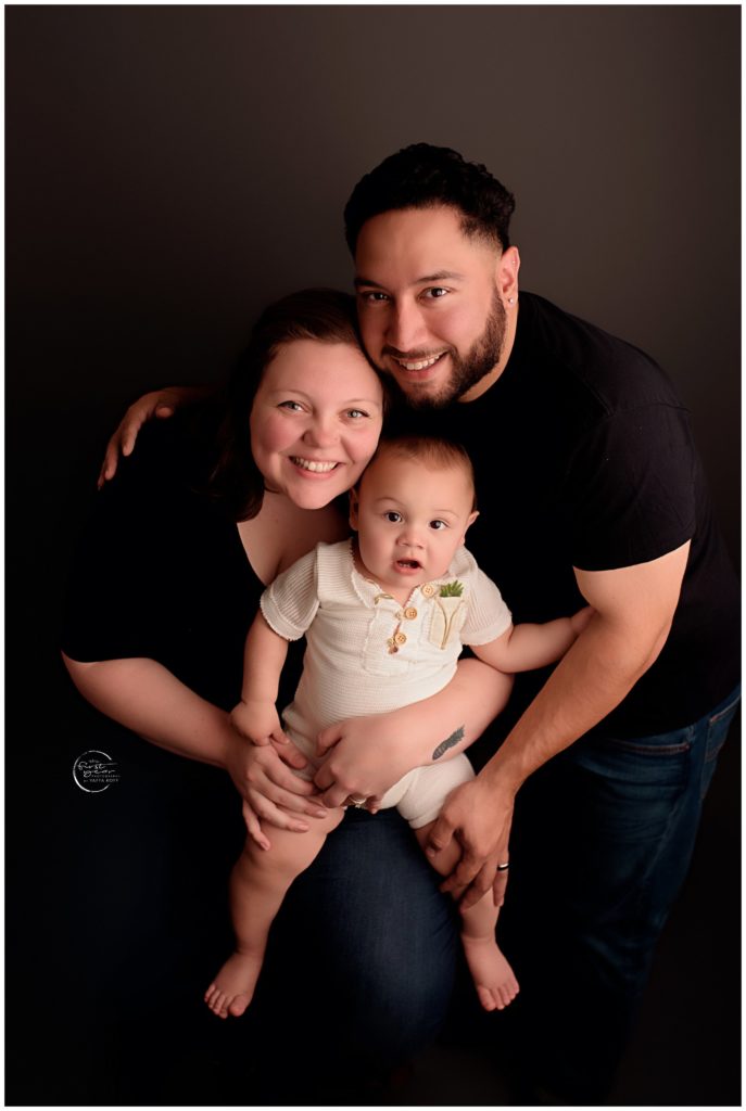 Happy family celebrating a child's first birthday in a professional studio.