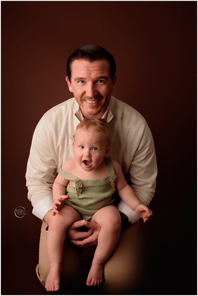 Family portrait of a father and baby girl celebrating a birthday with a cake smash.