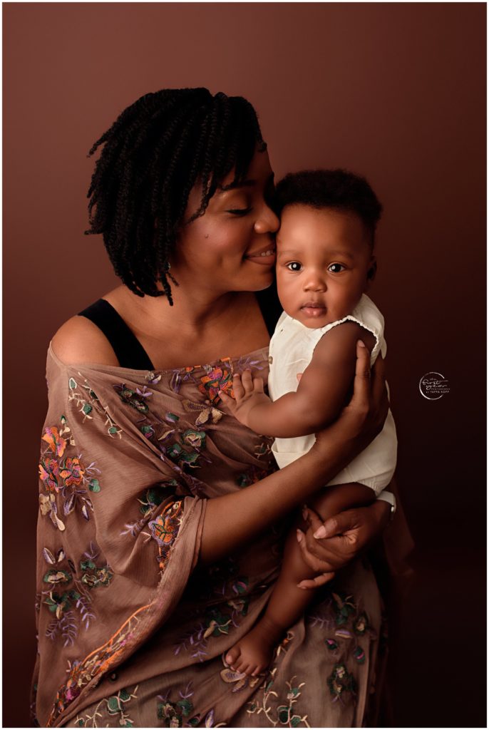 Mother holding her 6-month-old baby in a warm, intimate pose.