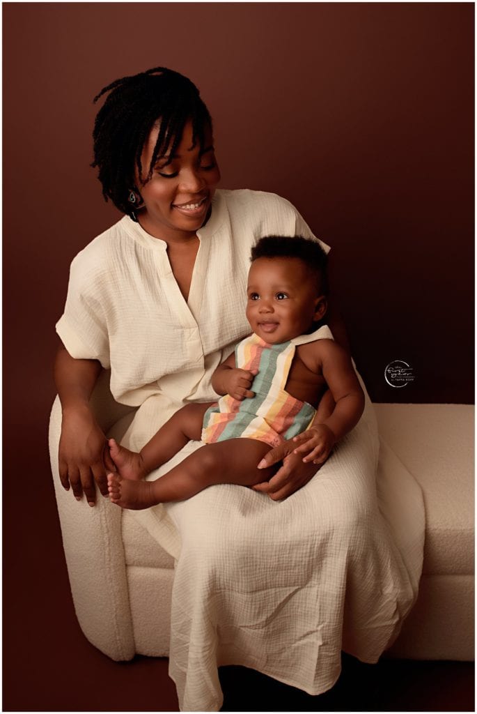 Mother holding smiling baby girl during a photoshoot in Silver Spring, MD.