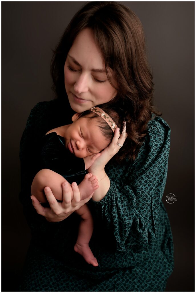 A tender moment capturing a mother holding her newborn baby during a portrait session in Silver Spri.