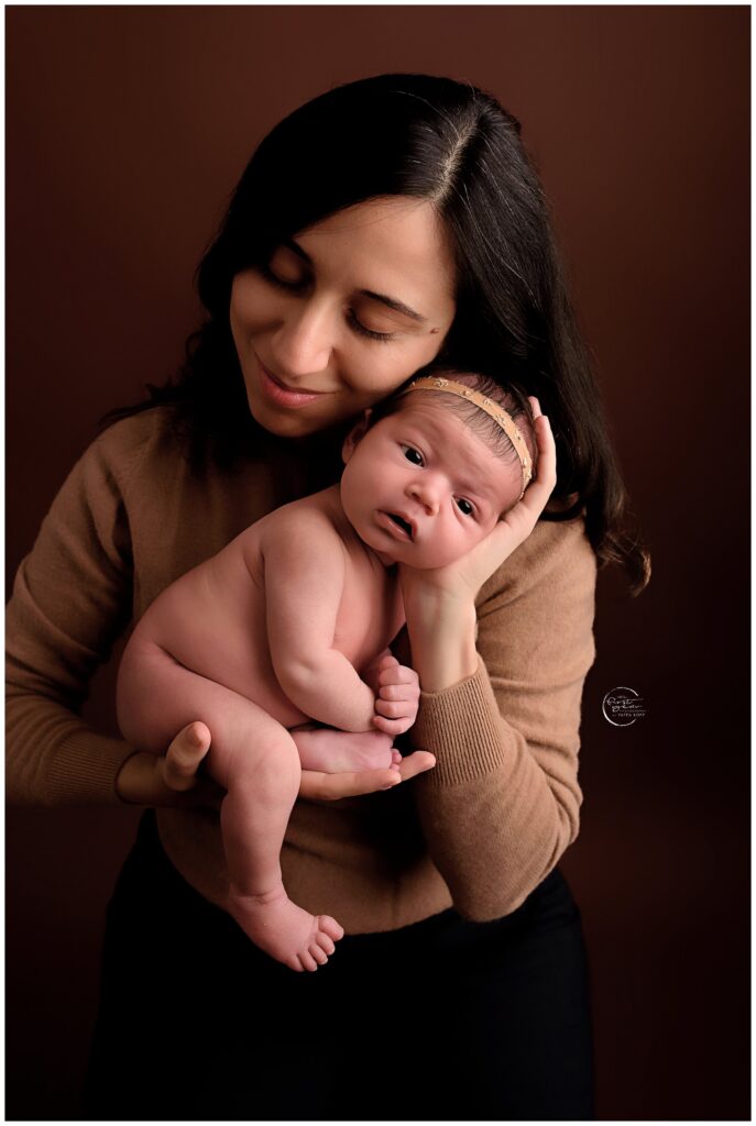 Newborn and mother portrait in studio, showcasing tender moments with a baby girl.
