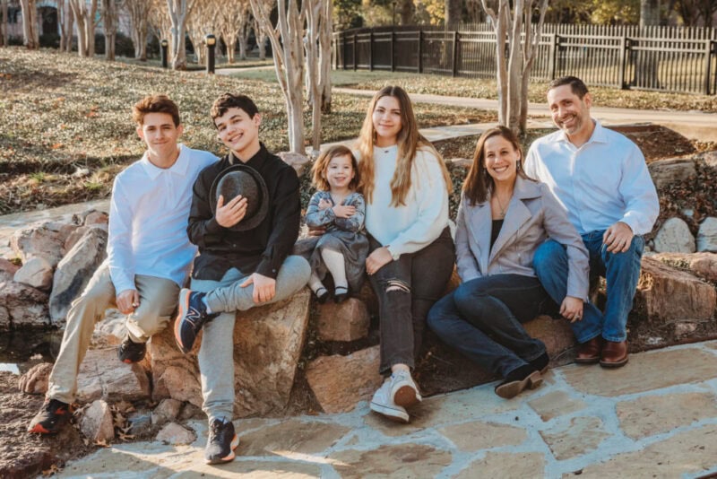 Beautiful family sitting outdoors in Silver Spring, Maryland, capturing joyful moments for a newborn.